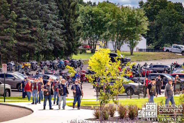 Riders and motorcycles massed in the lot before riding into town