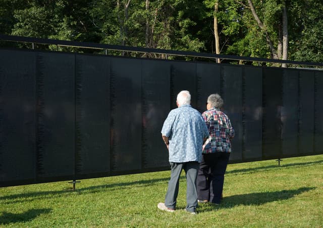 Two visitors stand quietly together at the Wall