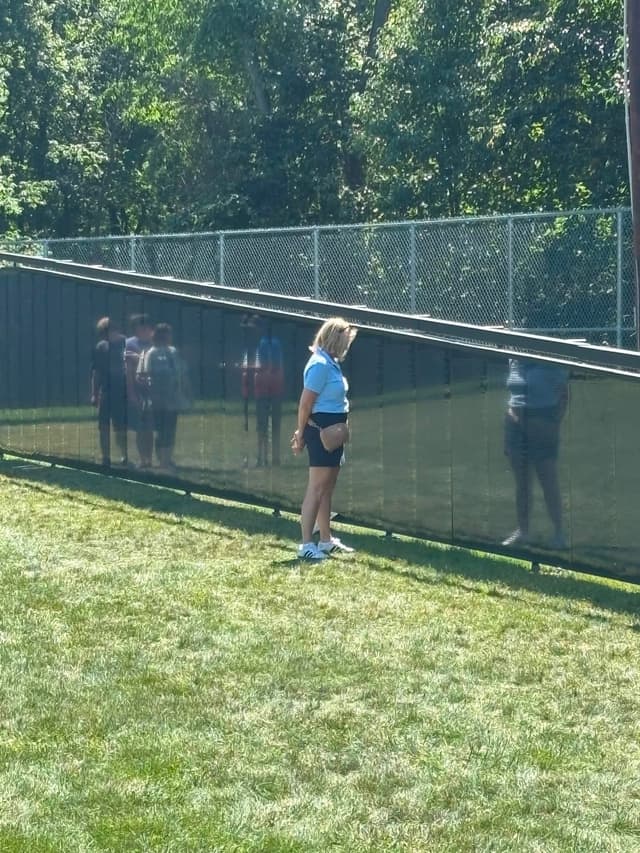 A visitor walks the path beside the Wall