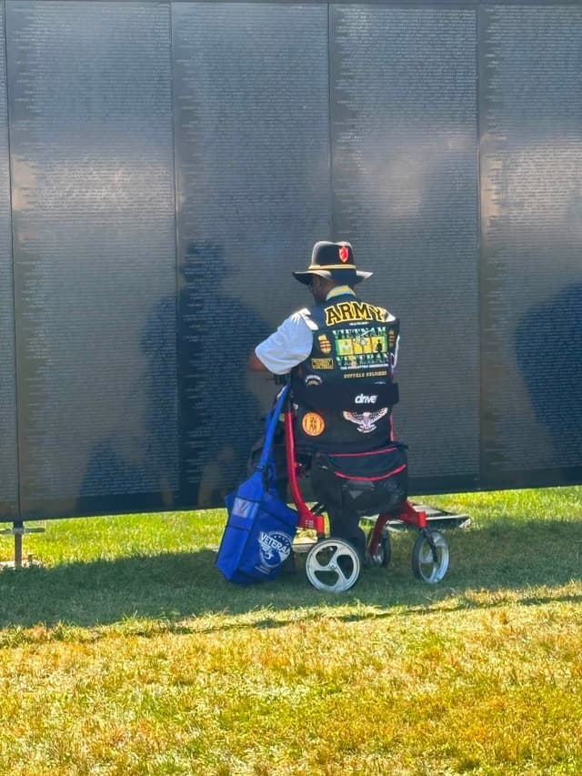 A veteran sits at the Wall in the afternoon